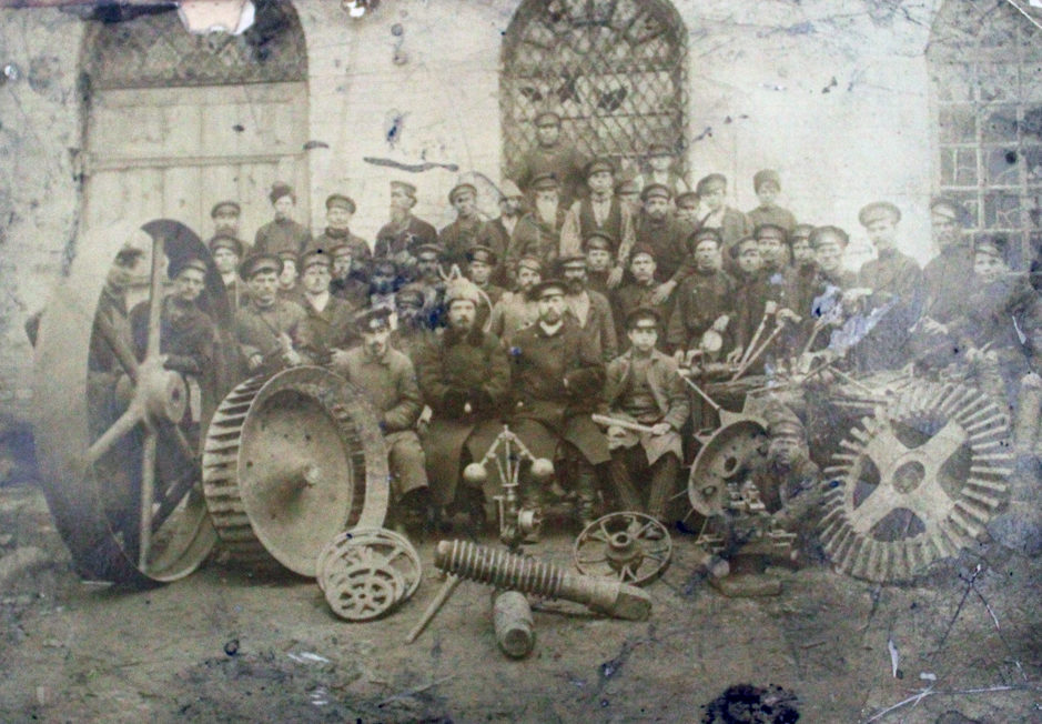 История города Режа: 1861 — 1917. Рабочие с инструментами на фоне цеха Режевского завода, начало ХХ века